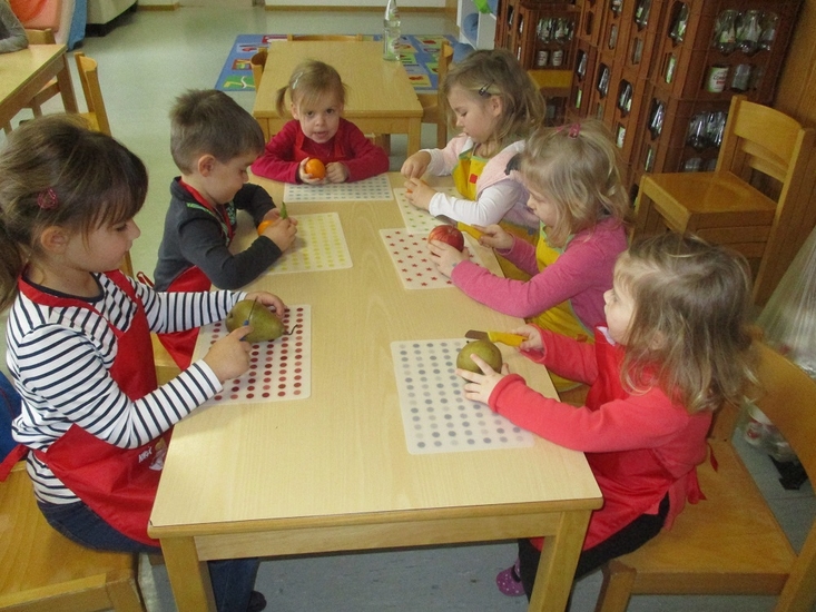 Kindergartenkinder beim Obst schneiden